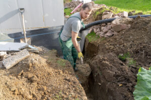 A man Digging ground to prepare for drainage home.