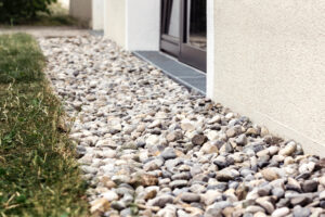Drain Gravel Floor with Crushed Stones along Wall Building. French Drain for Storm Water Around House. Drainage Outdoor.
